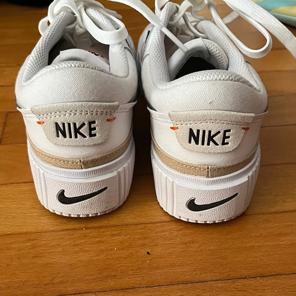 Nike White Sneakers with Black Swoosh and Gold Accent